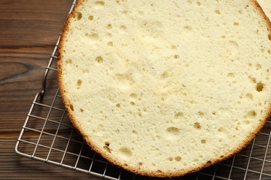 Photo of Tasty cut sponge cake on wooden table, closeup