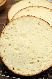 Photo of Tasty cut sponge cake on wooden table, closeup