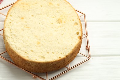 Photo of Tasty cut sponge cake on white wooden table, above view