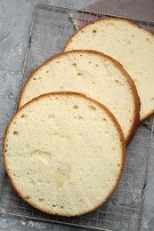 Delicious cut sponge cake on grey textured table, flat lay