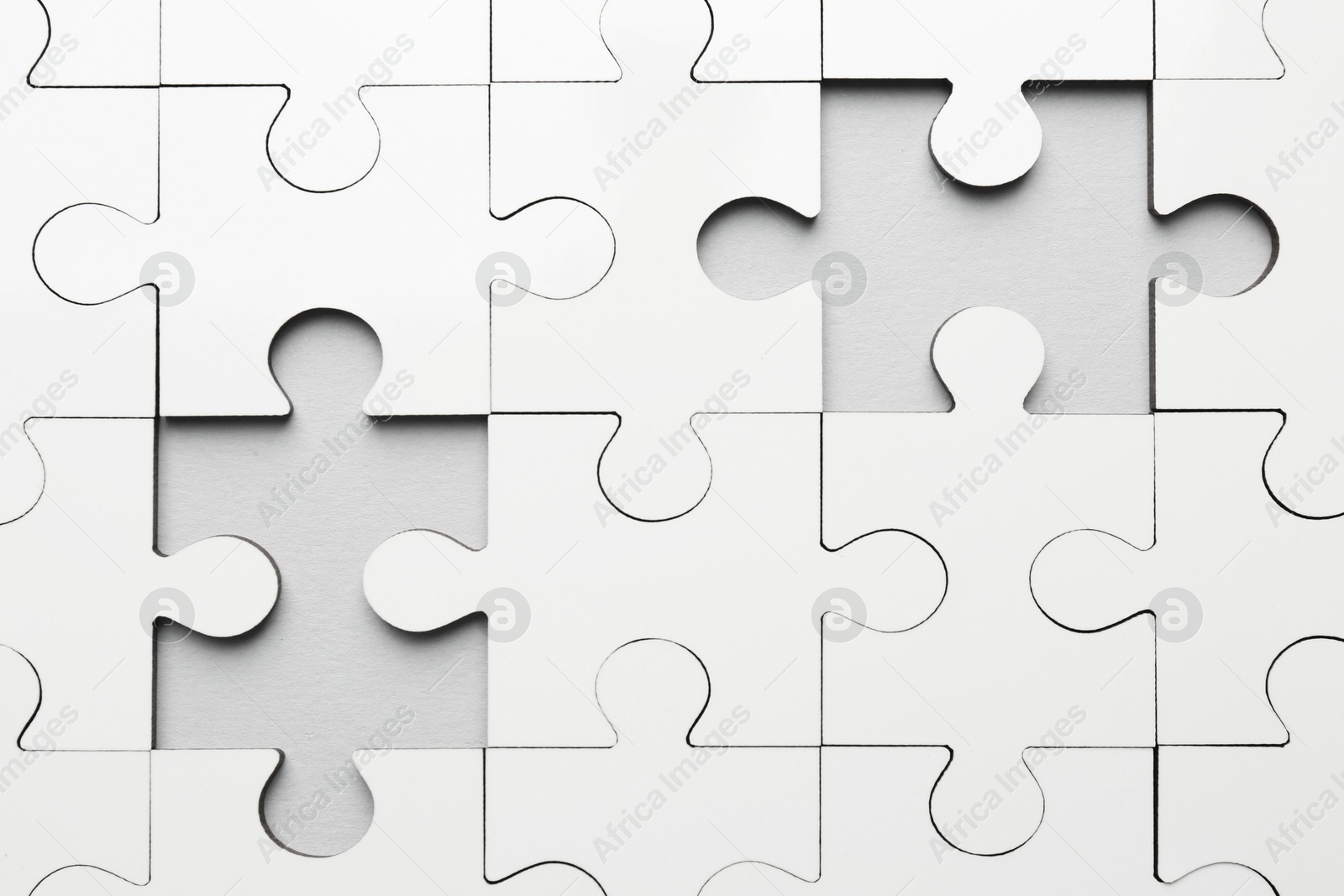 Photo of White puzzle pieces on grey background, top view