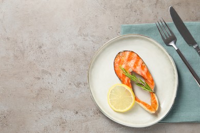 Photo of Tasty grilled salmon steak served on gray textured table, flat lay. Space for text