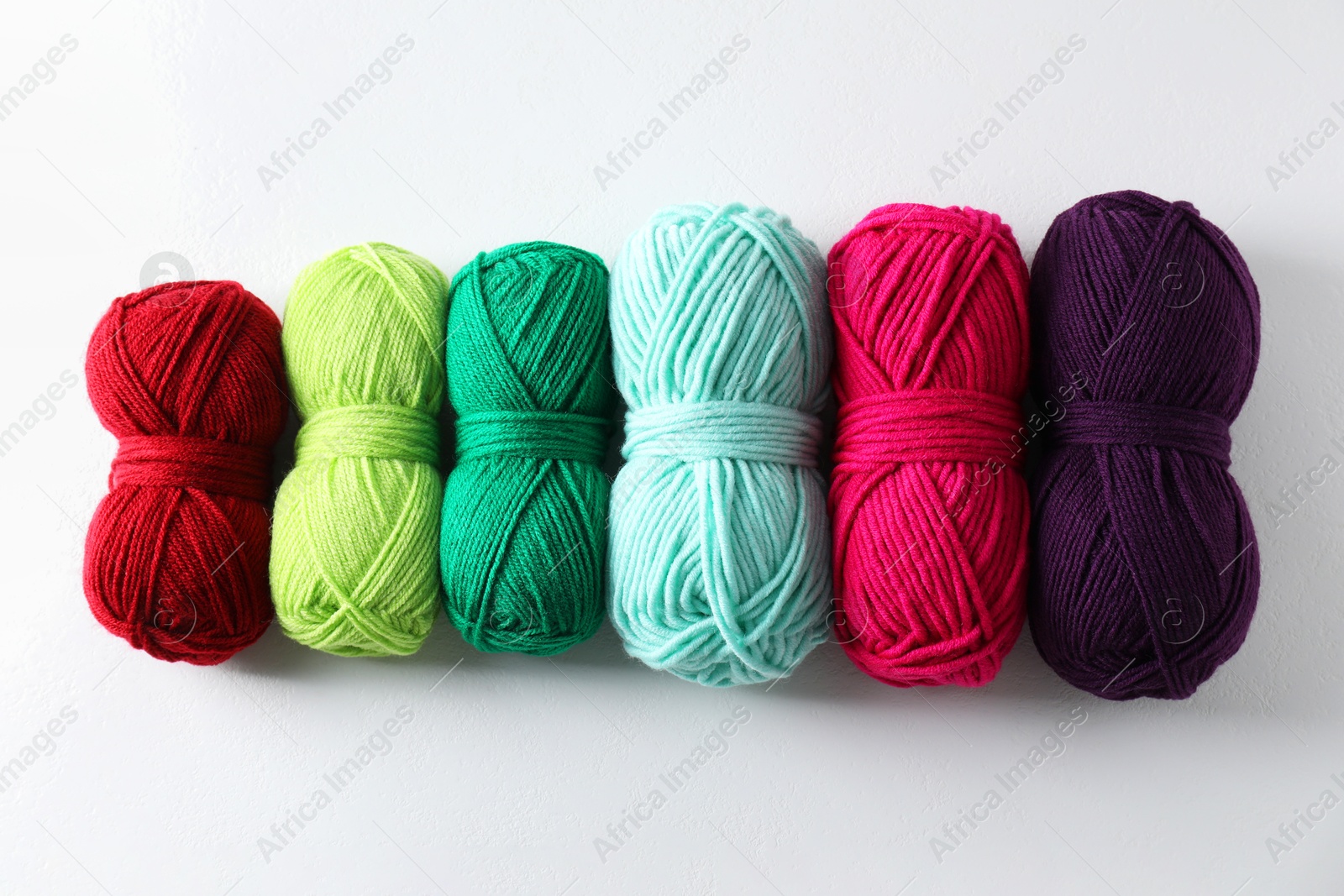 Photo of Many soft skeins of yarn on light grey background