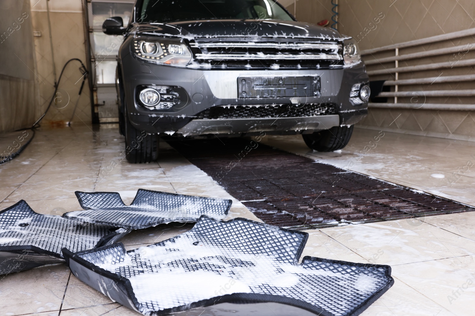 Photo of Car floor mats covered with foam and modern auto indoors