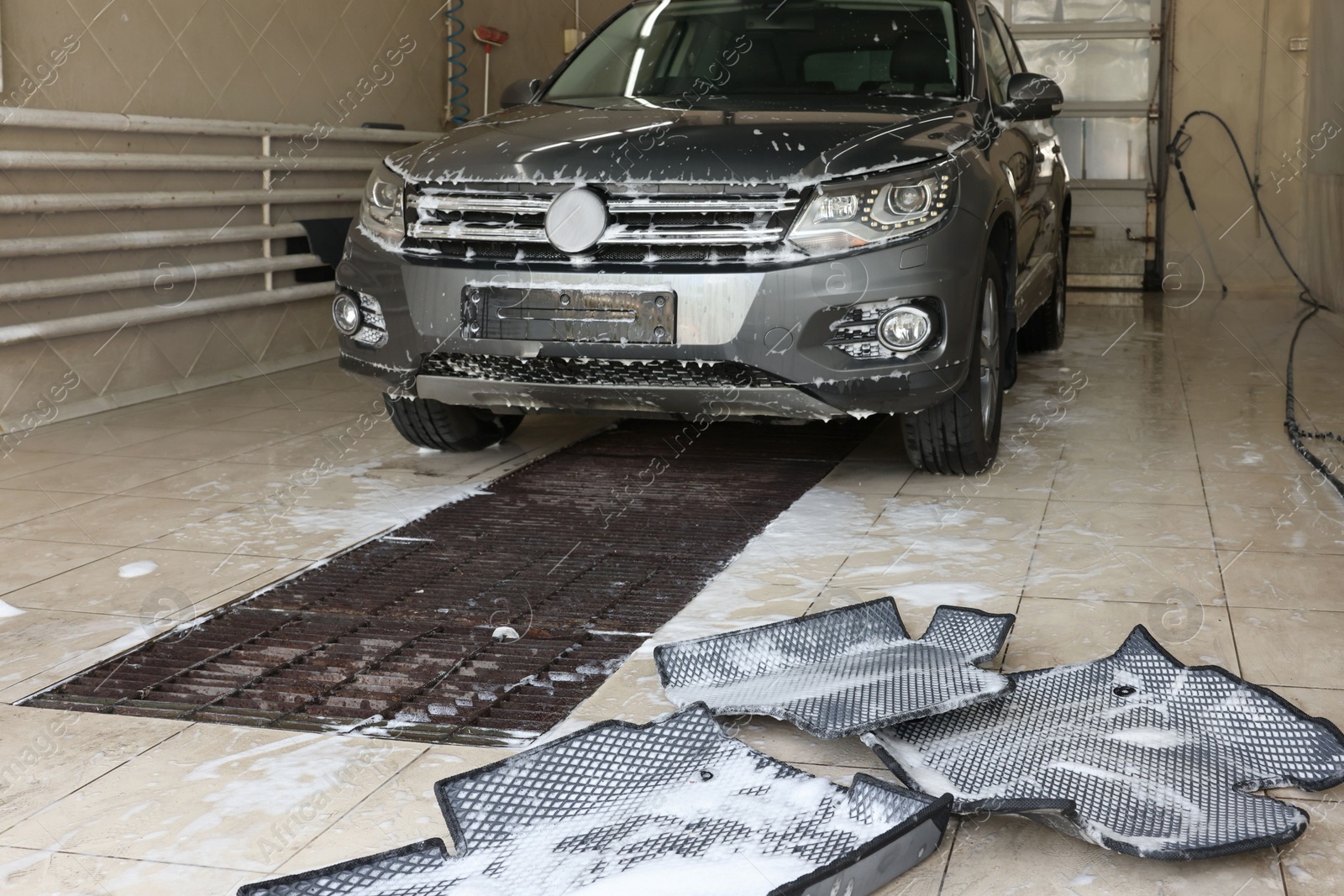 Photo of Car floor mats covered with foam and modern auto indoors