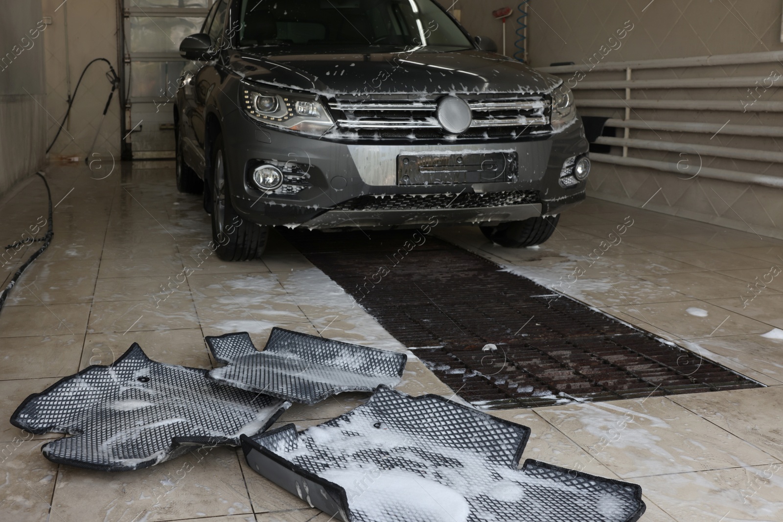 Photo of Car floor mats covered with foam and modern auto indoors