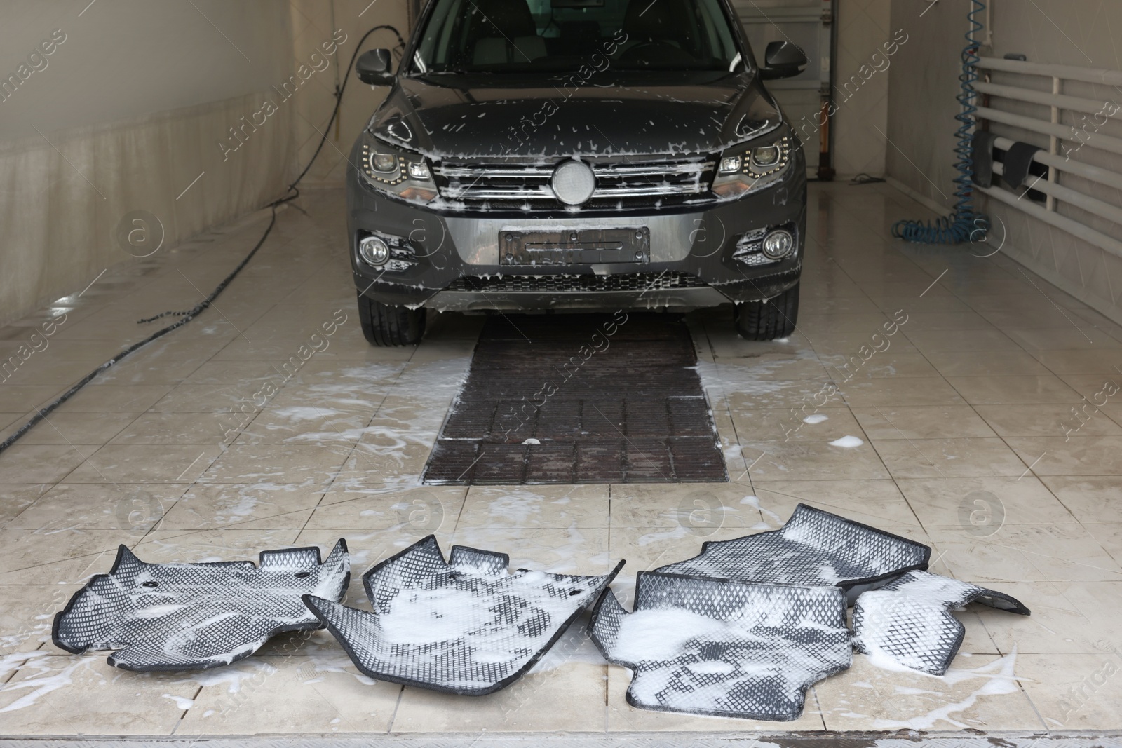 Photo of Car floor mats covered with foam and modern auto indoors