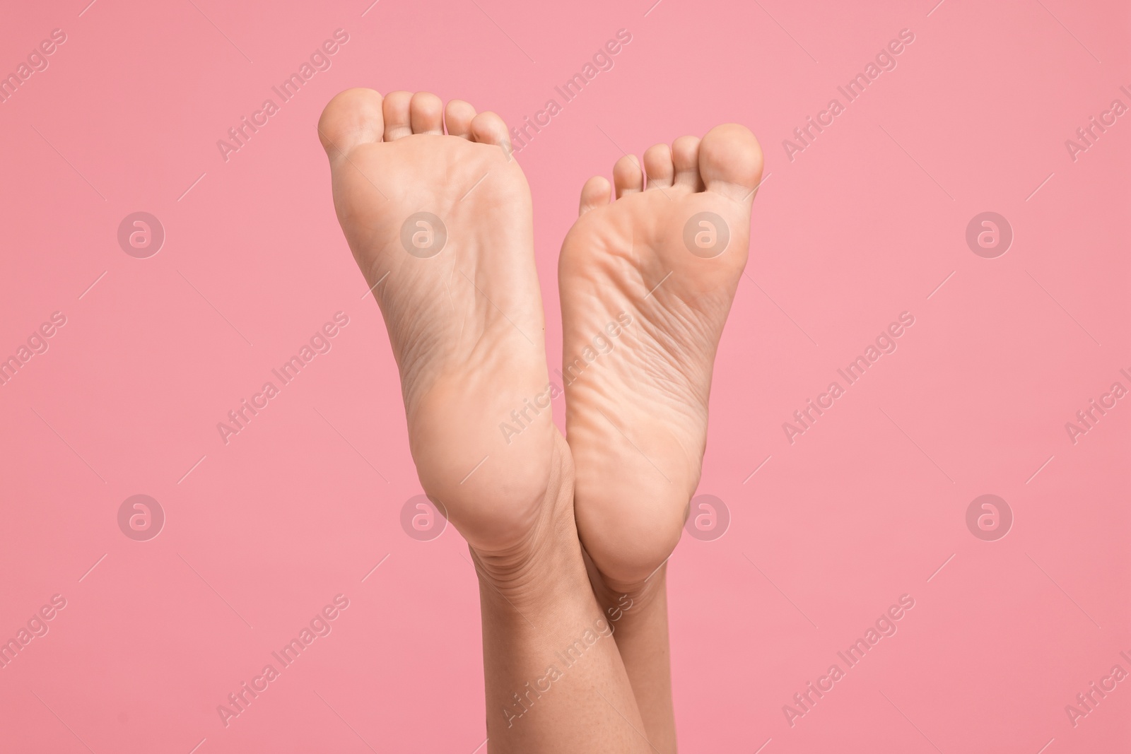 Photo of Woman with smooth feet on pink background, closeup