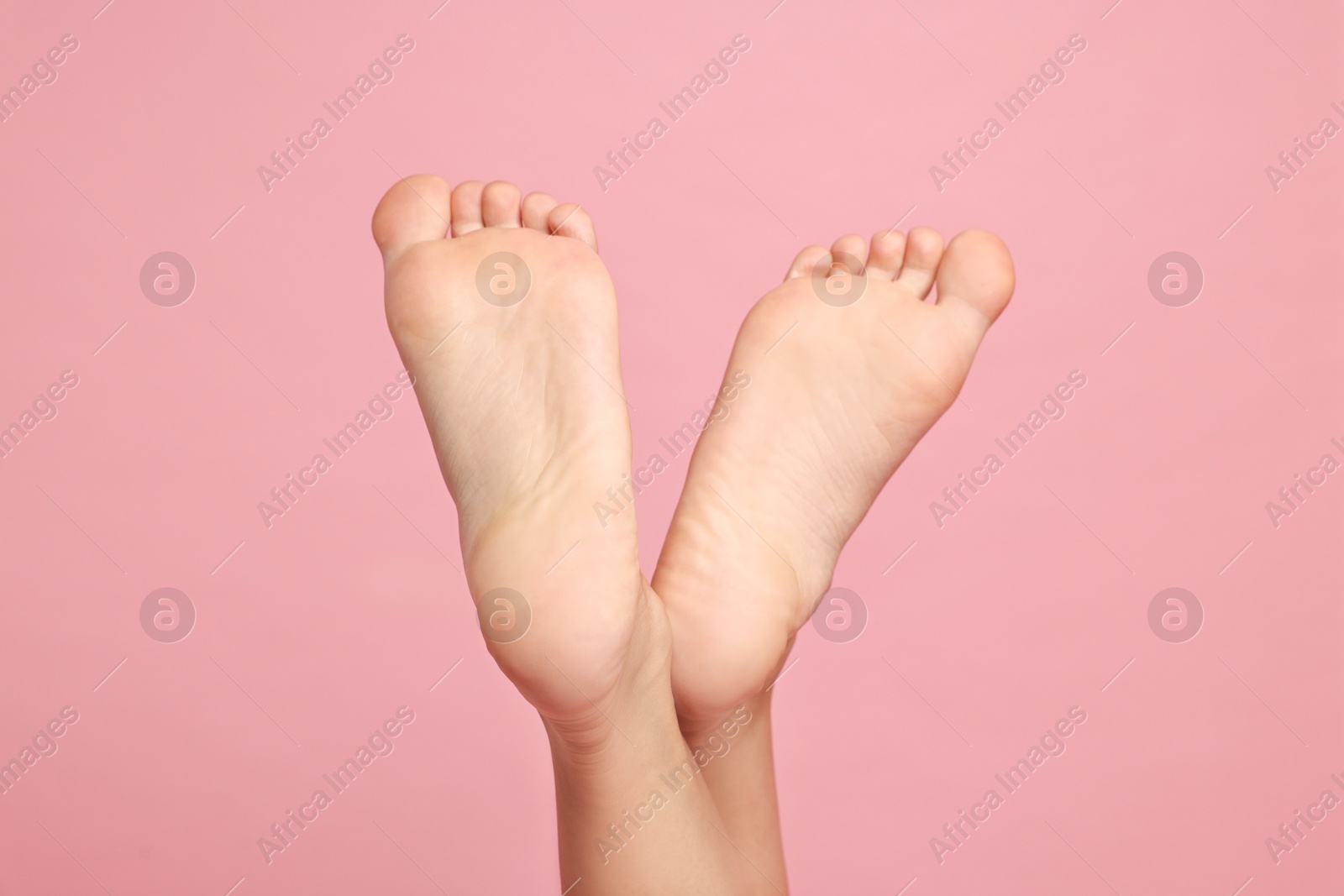 Photo of Woman with smooth feet on pink background, closeup