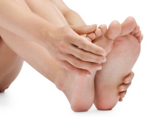 Photo of Woman touching her smooth feet on white background, closeup