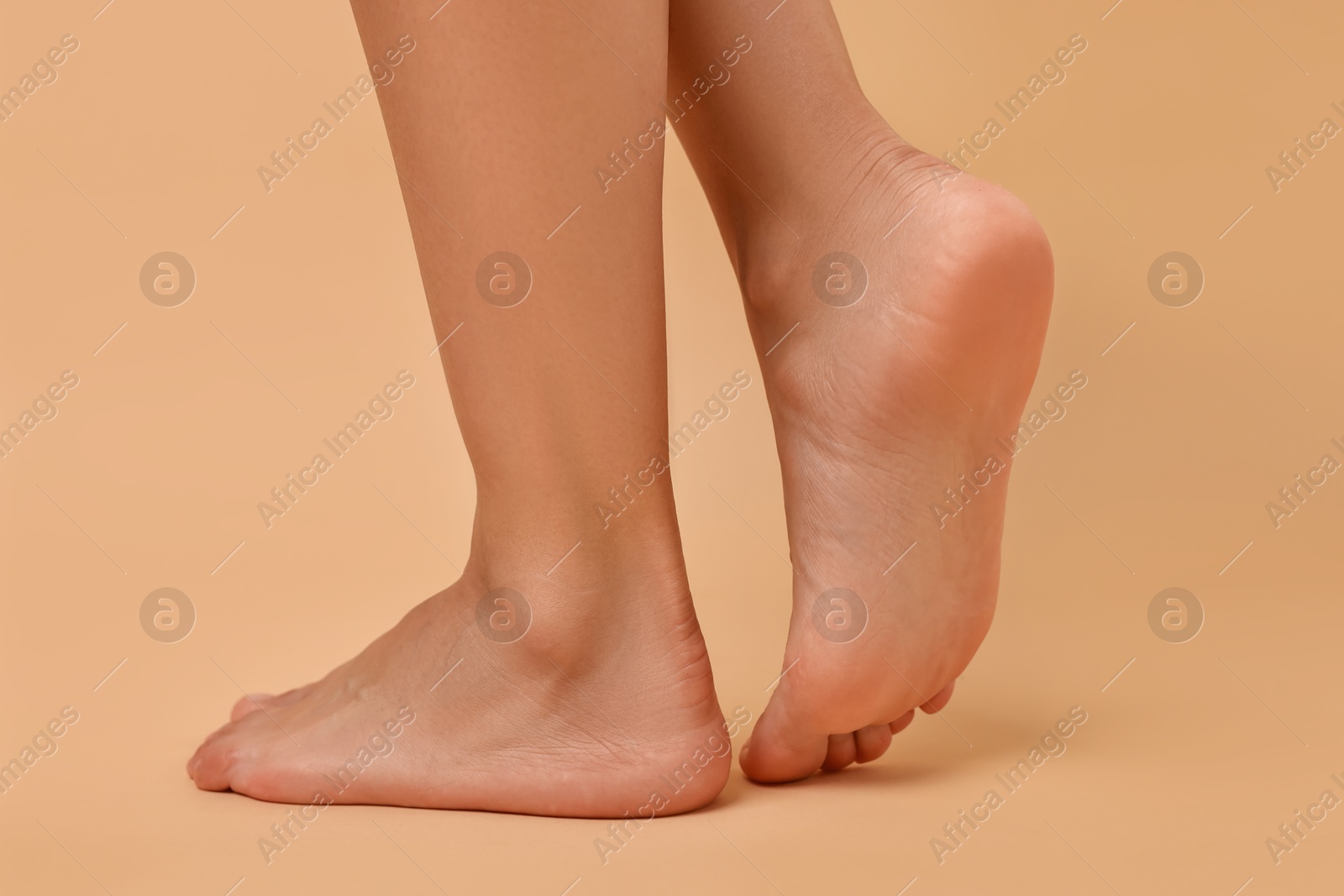 Photo of Woman with smooth feet on beige background, closeup