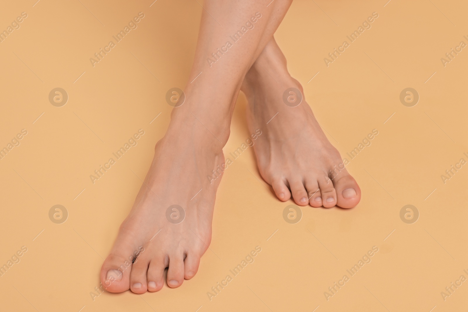 Photo of Woman with smooth feet on beige background, closeup