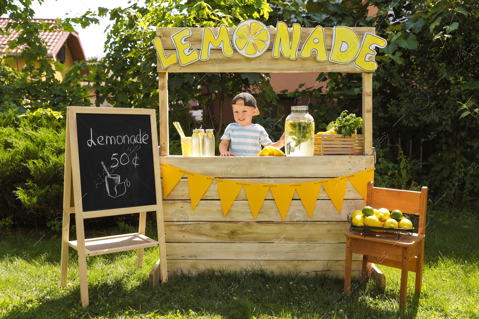 Photo of Cute little boy at lemonade stand in park