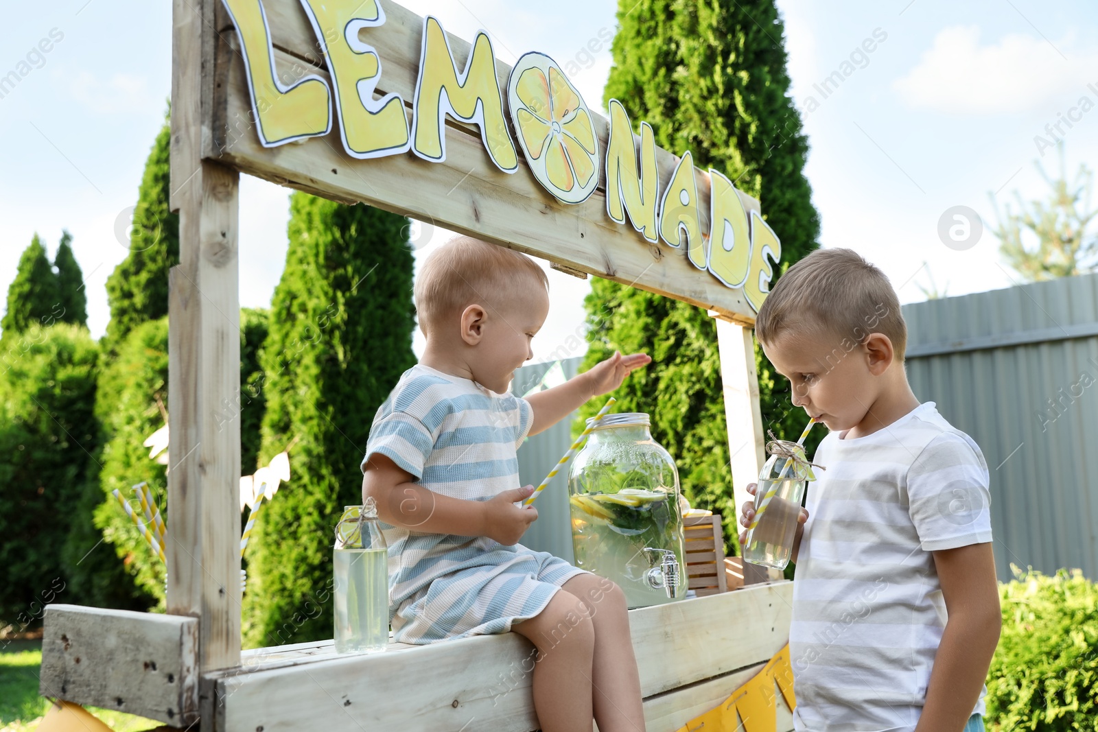 Photo of Cute little boys near lemonade stand in park