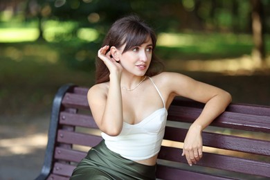 Beautiful woman sitting on bench in park