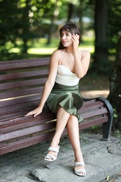 Beautiful woman sitting on bench in park