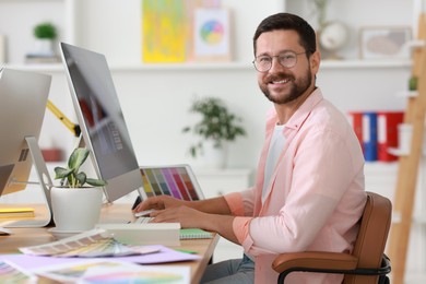 Designer working with computer at table in office