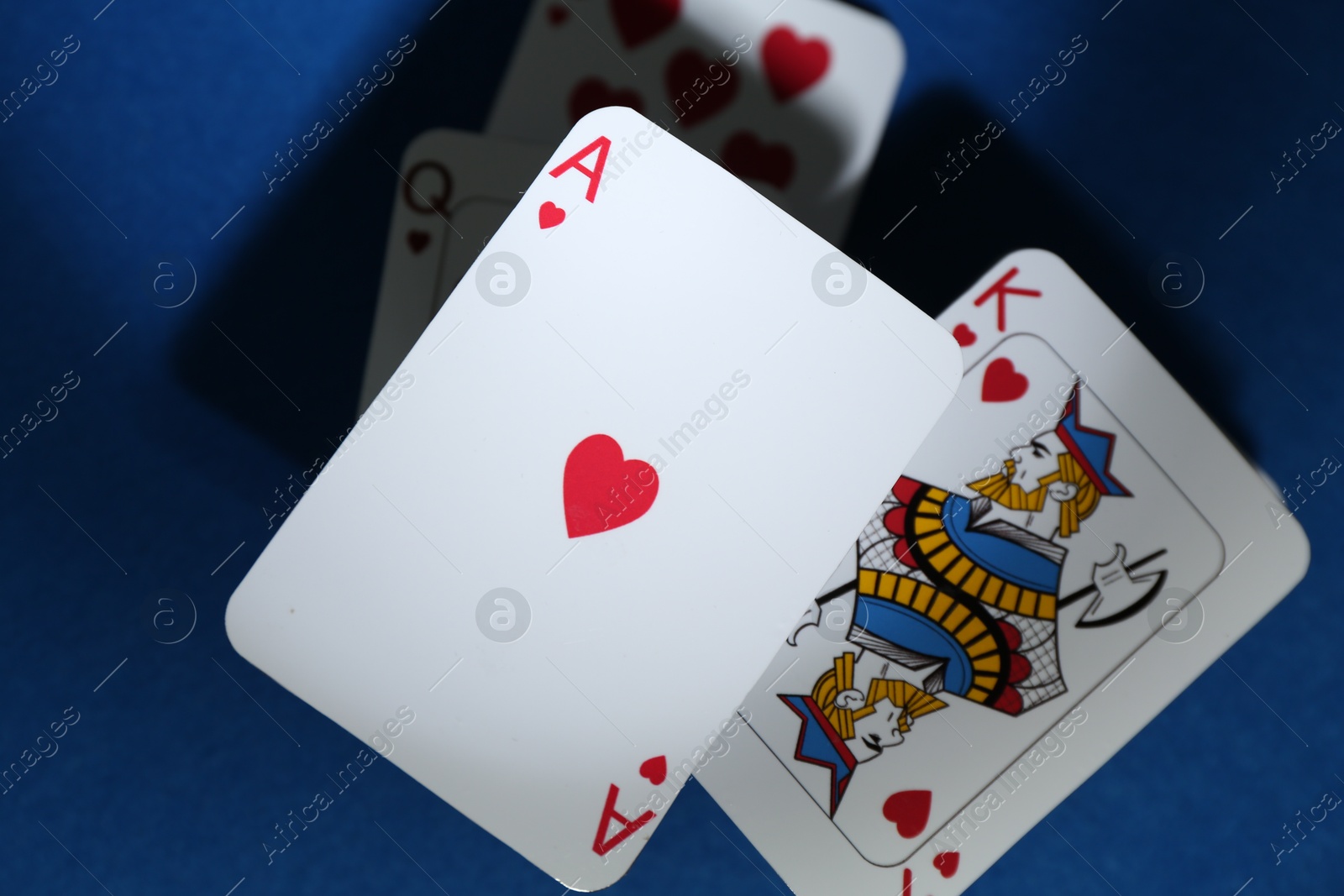 Photo of Poker game. Playing cards on blue table, top view