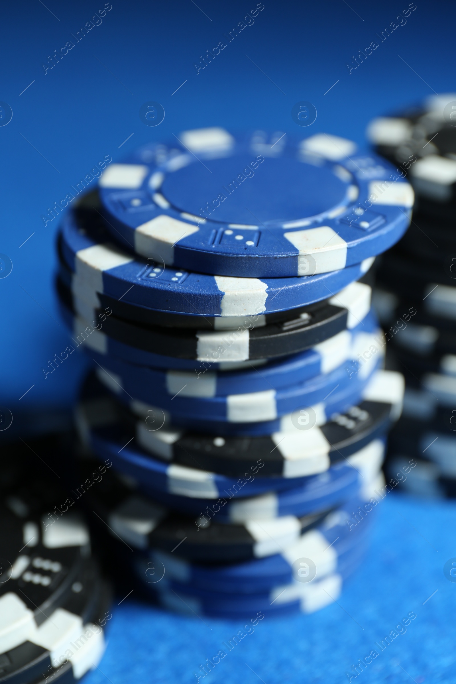 Photo of Poker game. Casino chips on blue table, closeup