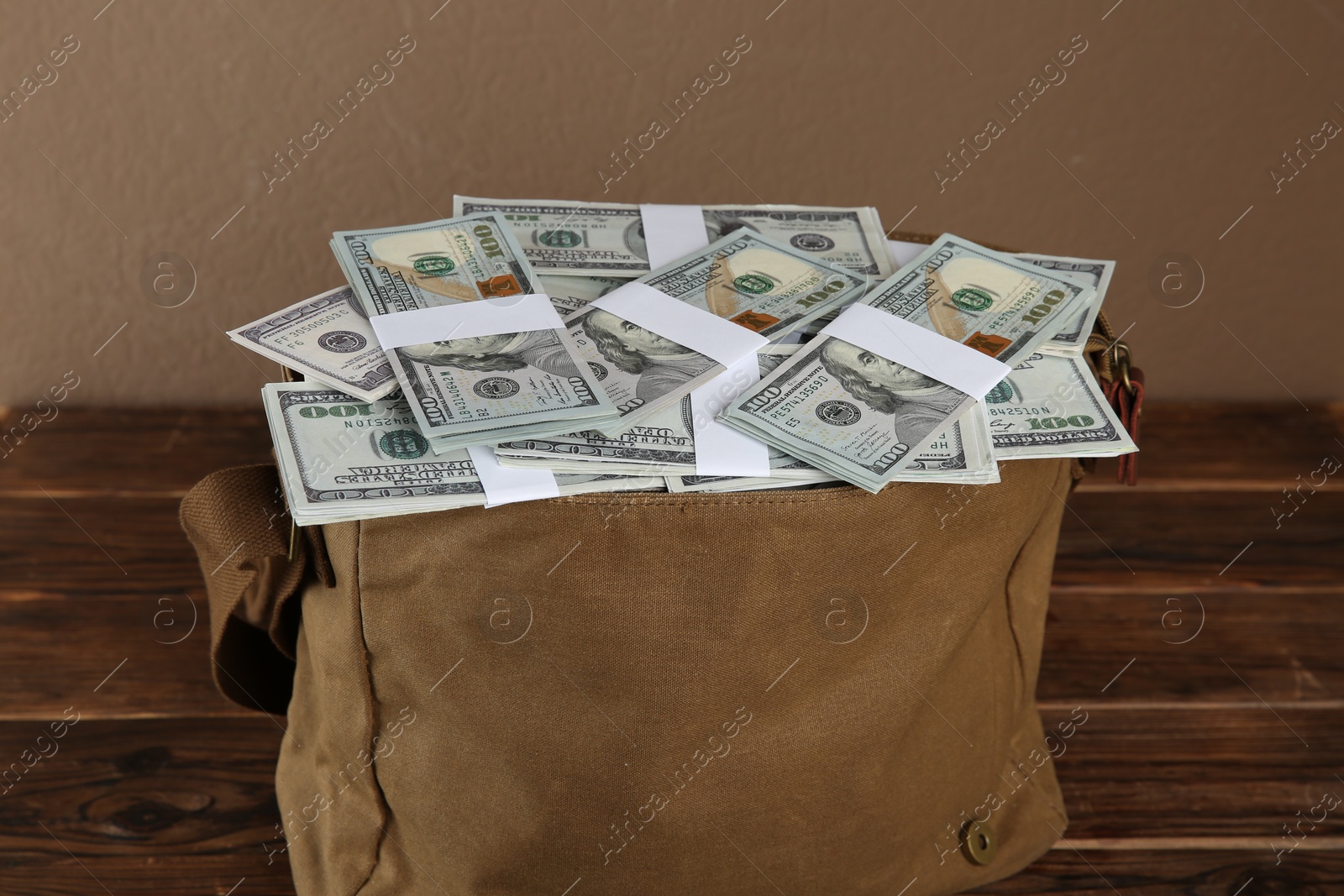 Photo of Dollar banknotes in bag on wooden table