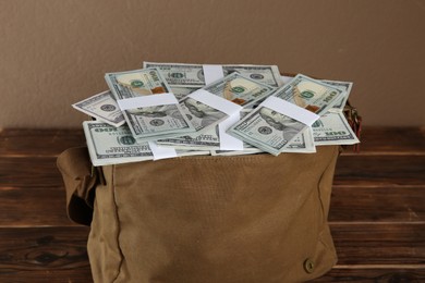 Photo of Dollar banknotes in bag on wooden table