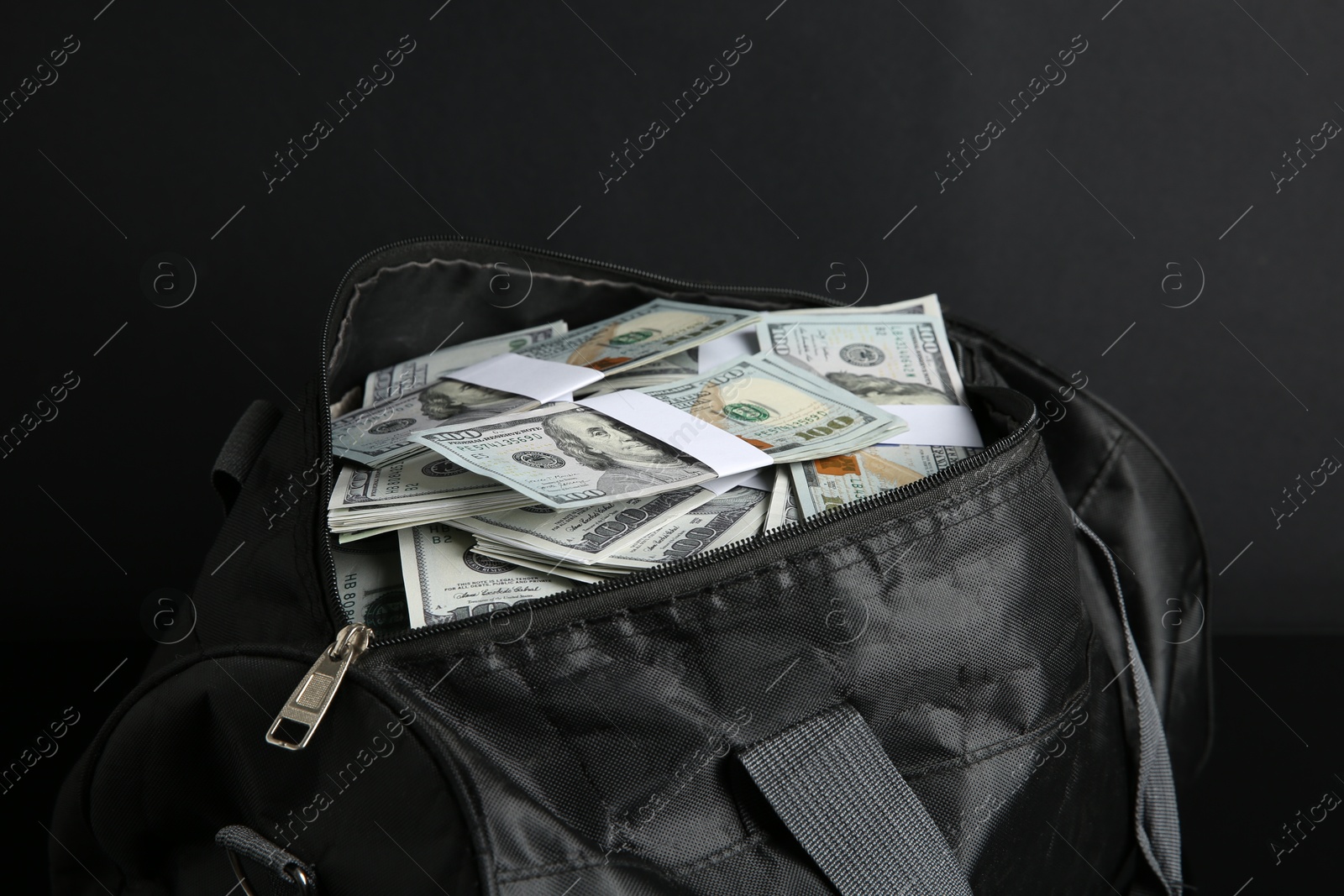 Photo of Dollar banknotes in bag on black background, closeup