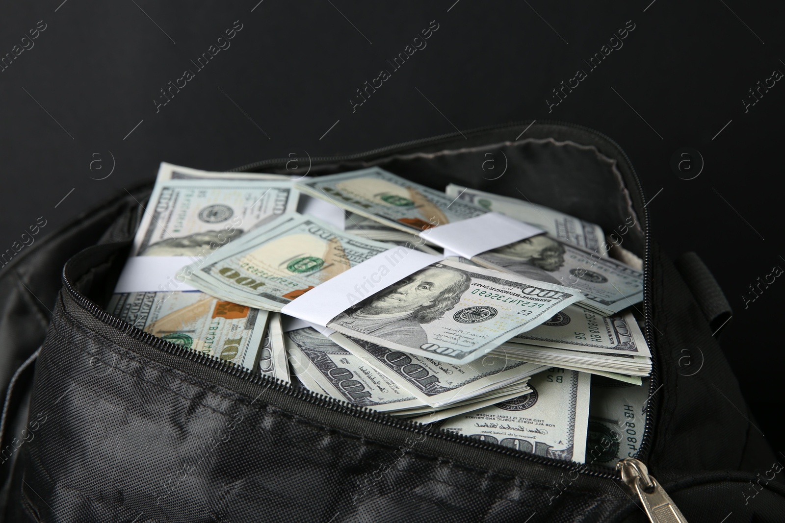 Photo of Dollar banknotes in bag on black background, closeup