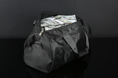 Photo of Dollar banknotes in bag on black mirror surface