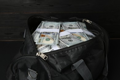 Photo of Dollar banknotes in bag on black table, closeup