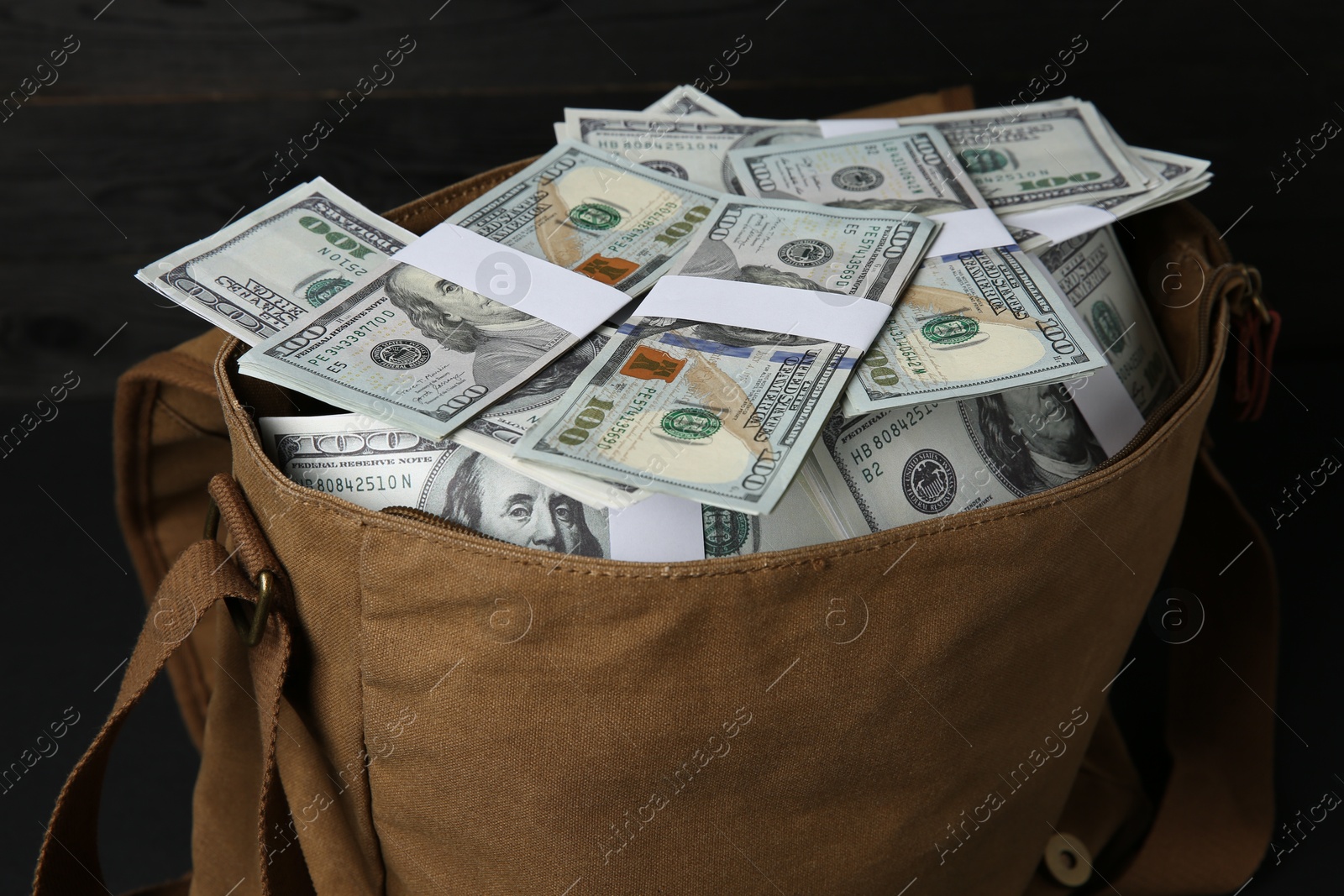 Photo of Dollar banknotes in bag on table, closeup