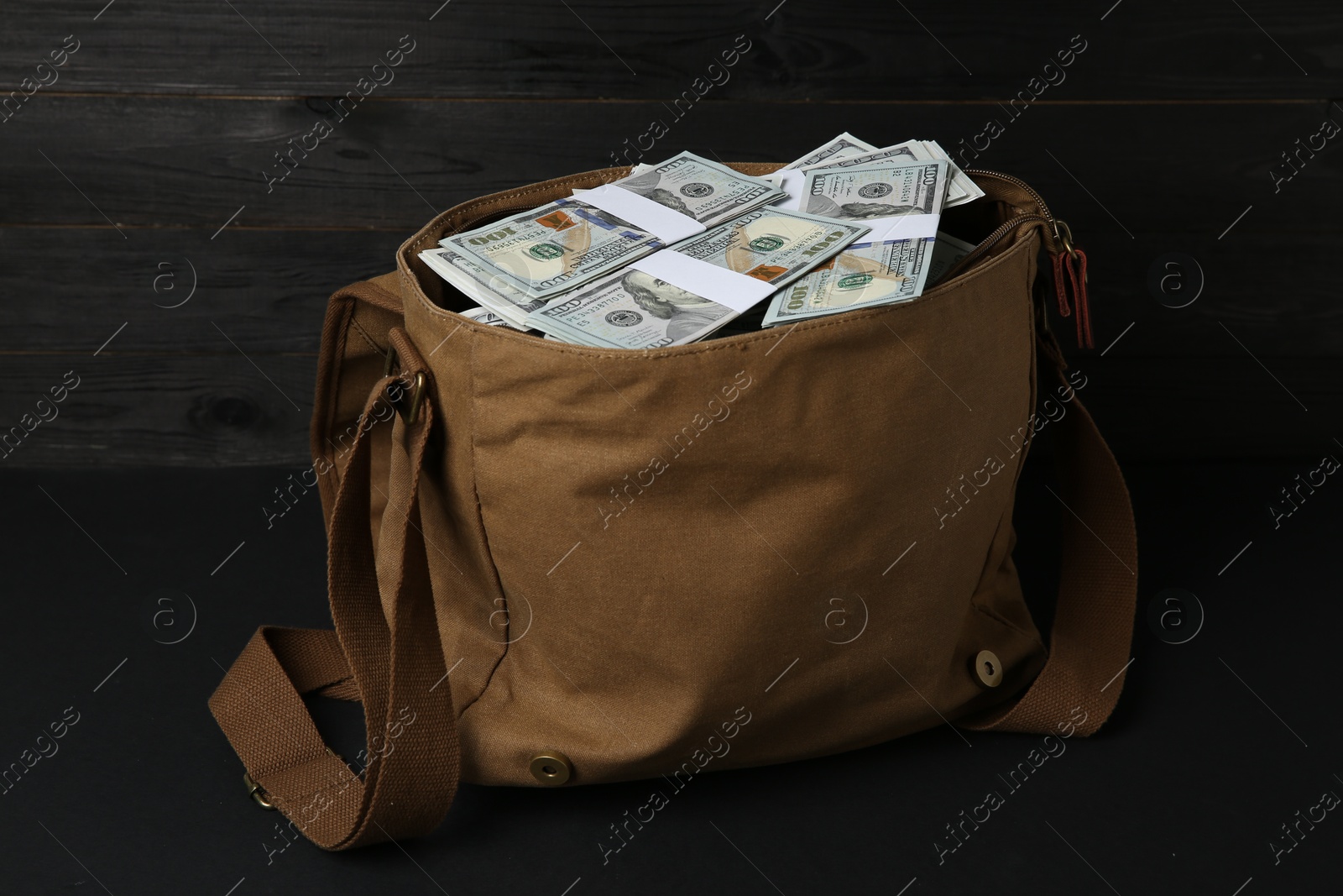 Photo of Dollar banknotes in bag on black table