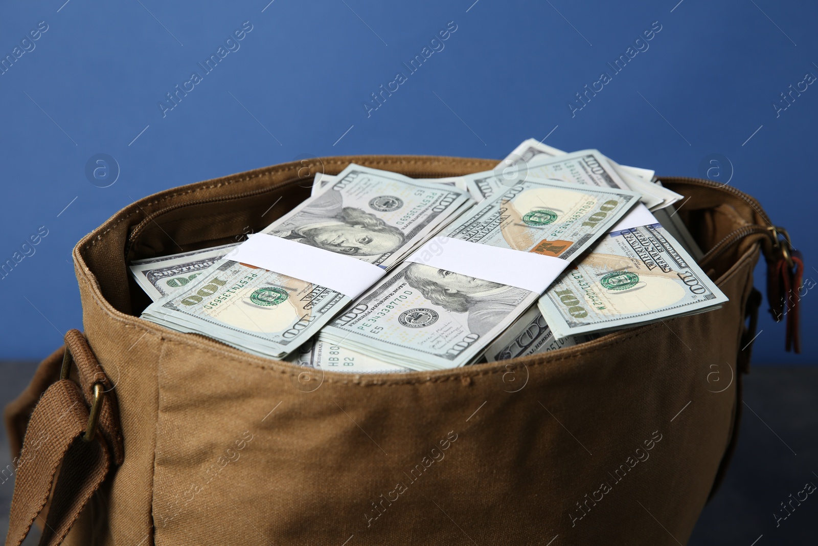 Photo of Dollar banknotes in bag on table, closeup