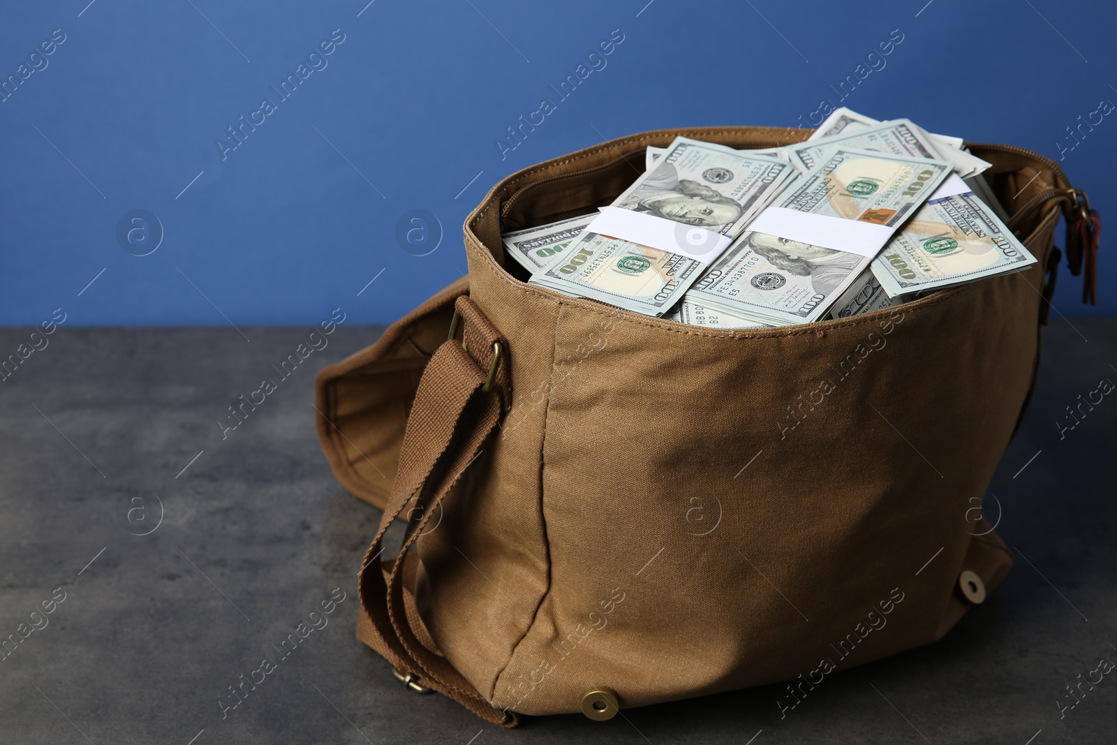 Photo of Dollar banknotes in bag on grey table