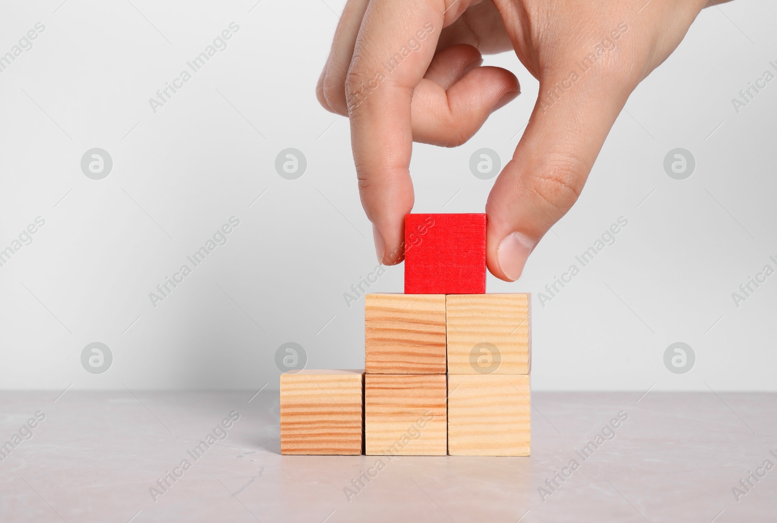 Photo of Woman with wooden cubes at light table, closeup