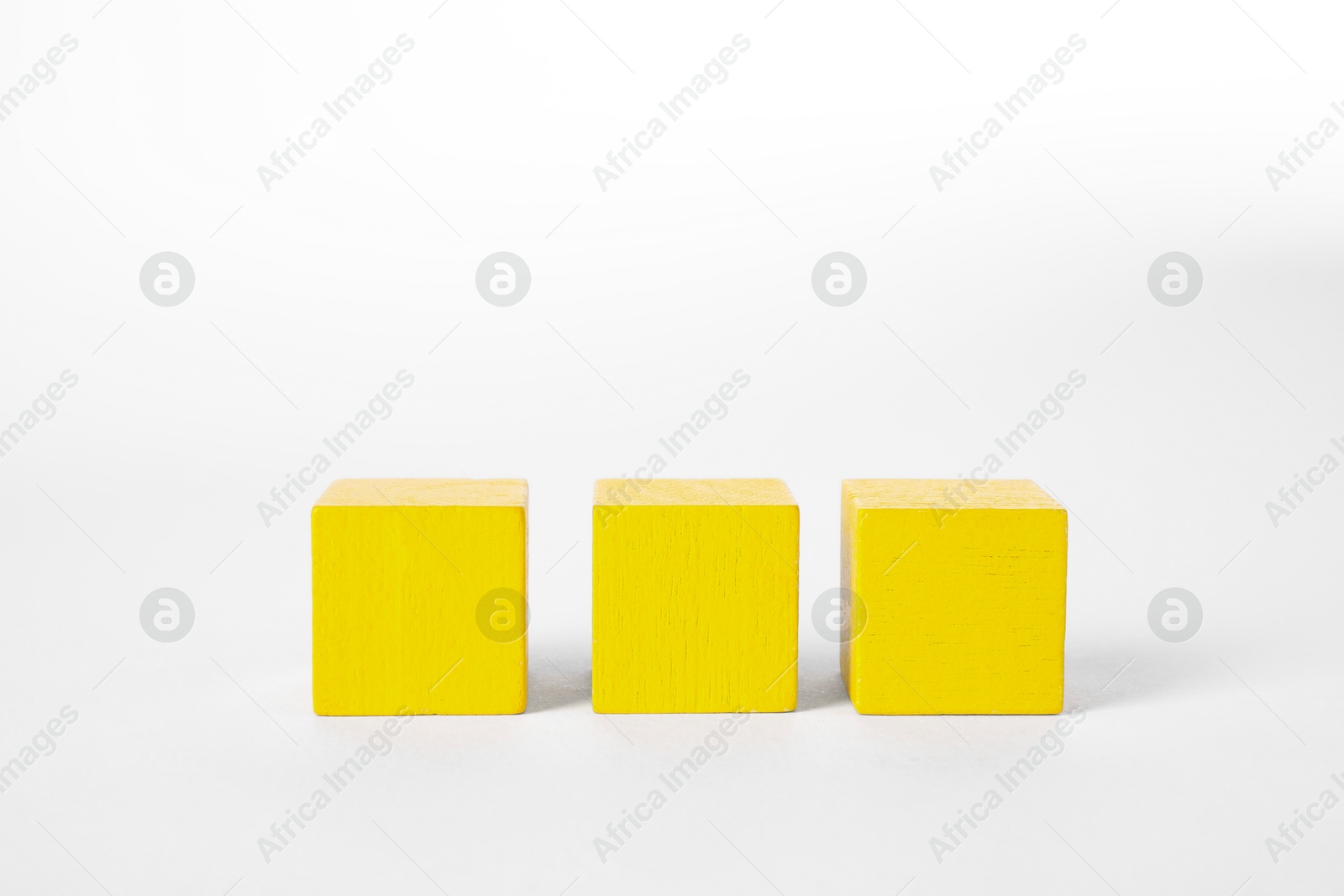 Photo of Many yellow wooden cubes isolated on white