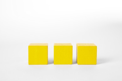 Many yellow wooden cubes isolated on white