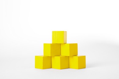 Photo of Many yellow wooden cubes isolated on white