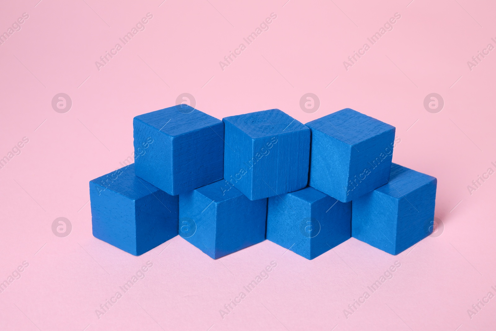 Photo of Many blank blue cubes on pink background