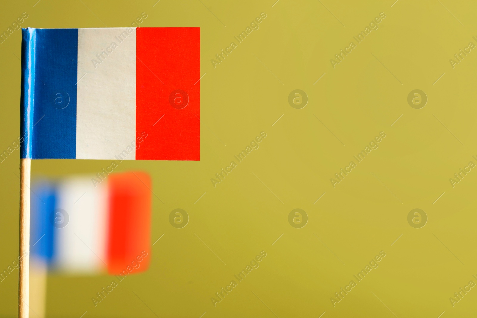 Photo of Small paper flags of France on olive background, space for text