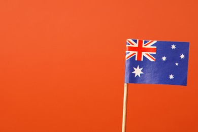 Small paper flag of Australia on orange background, space for text