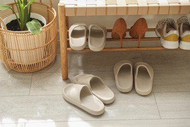 Photo of Many pairs of slippers and other shoes in entryway at home