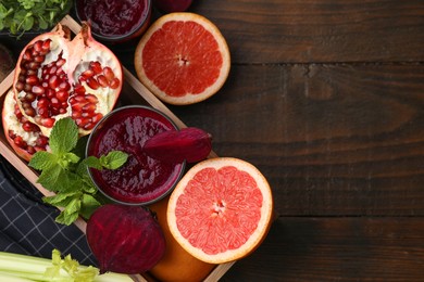 Photo of Glass of tasty beetroot smoothie, fresh vegetables, fruits and mint in box on wooden table, top view with space for text. Vegan drink