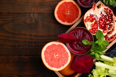 Glass of tasty beetroot smoothie, fresh vegetables, fruits and mint in box on wooden table, top view with space for text. Vegan drink