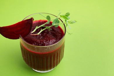 Vegan drink. Tasty beetroot smoothie with microgreens in glass on green table, closeup. Space for text