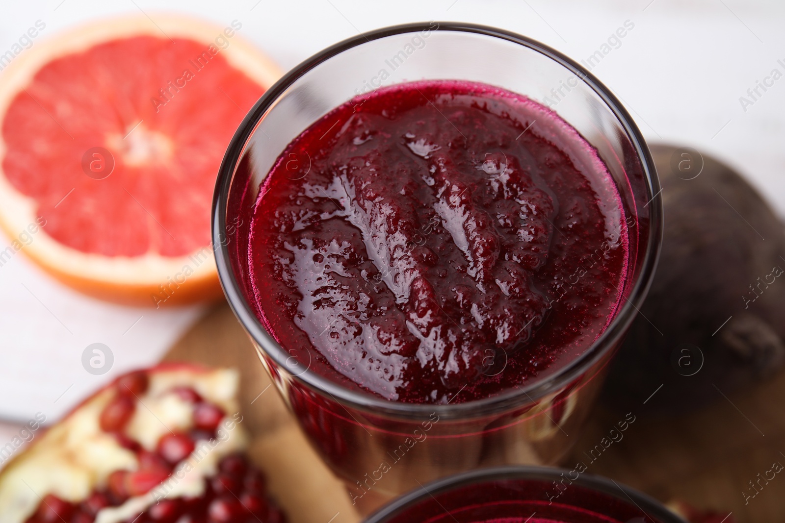 Photo of Tasty fresh beetroot smoothie on table, closeup. Vegan drink