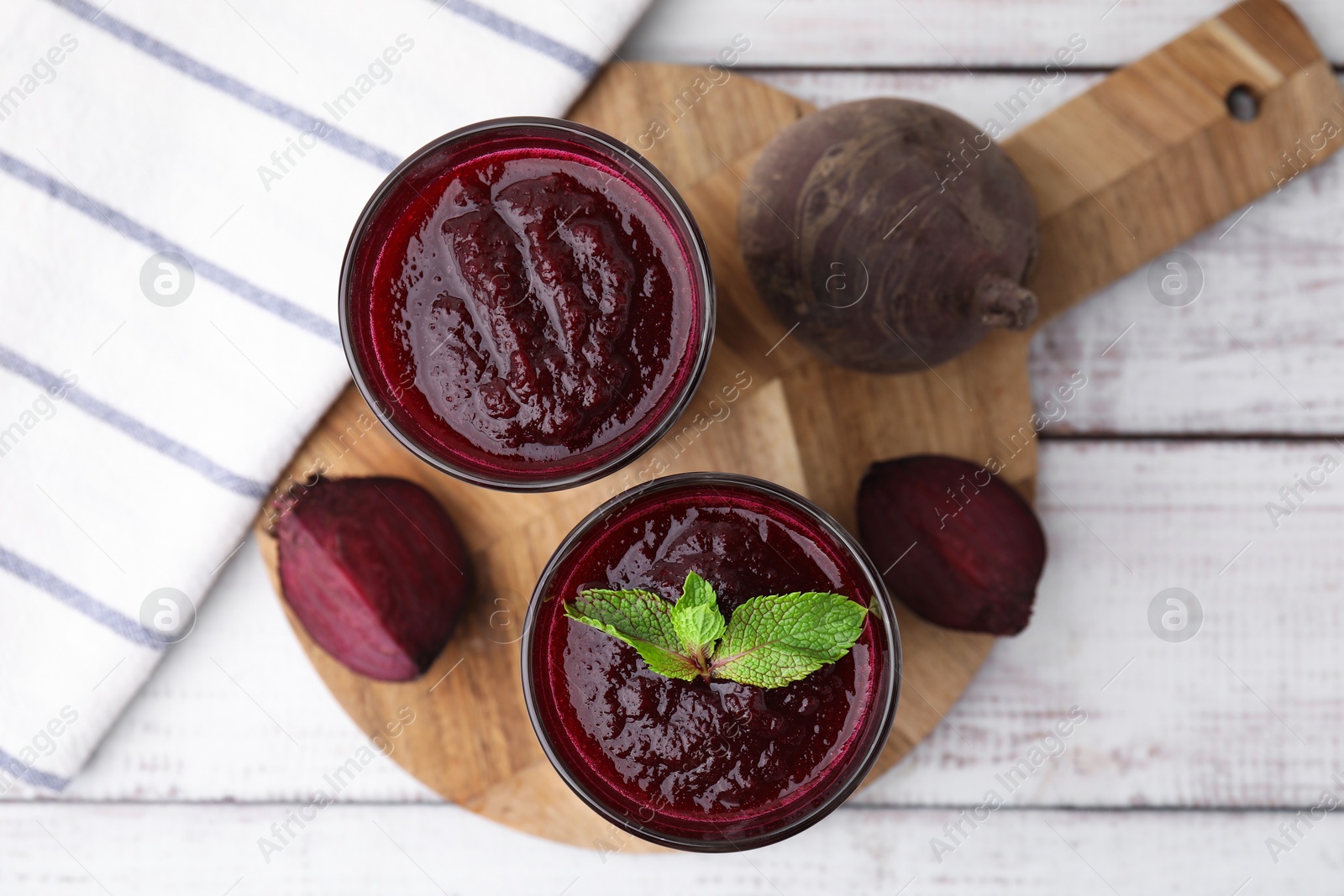 Photo of Fresh beetroot smoothie in glasses on white wooden table, flat lay