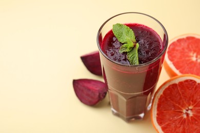 Photo of Fresh beetroot smoothie in glass, grapefruit and beet on beige background, space for text