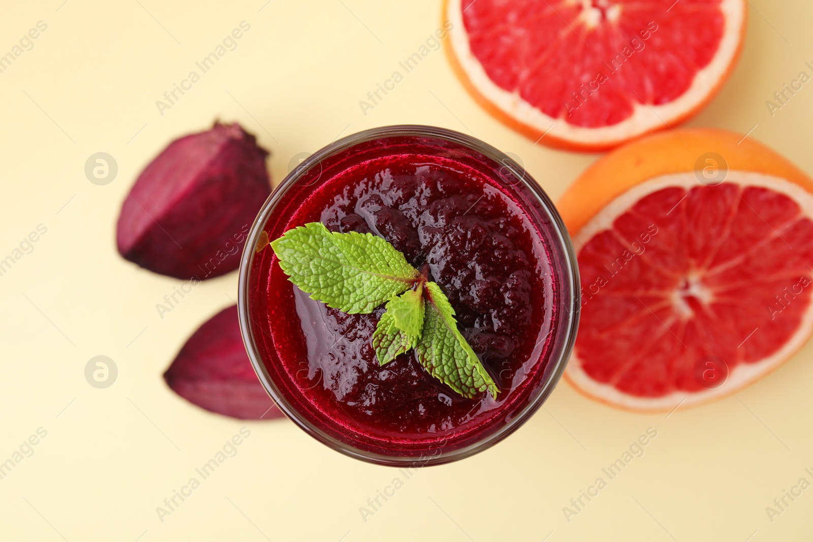 Photo of Fresh beetroot smoothie in glass, grapefruit and beet on beige background, top view