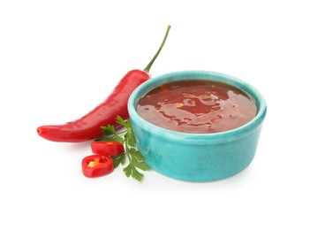 Photo of Hot chili sauce in bowl, parsley and pepper isolated on white