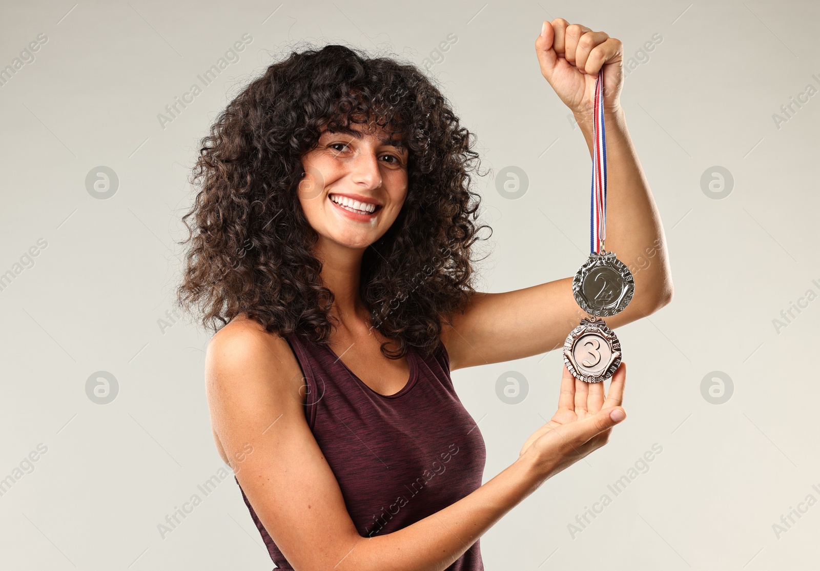 Photo of Happy winner with different medals on light grey background